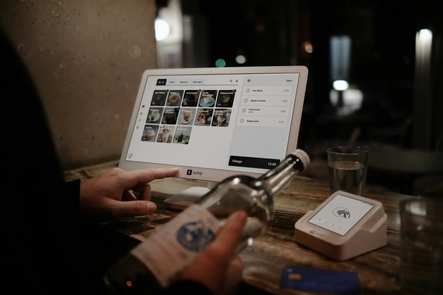 Restaurantleder arbejder digitalt ved en computer i en moderne bar